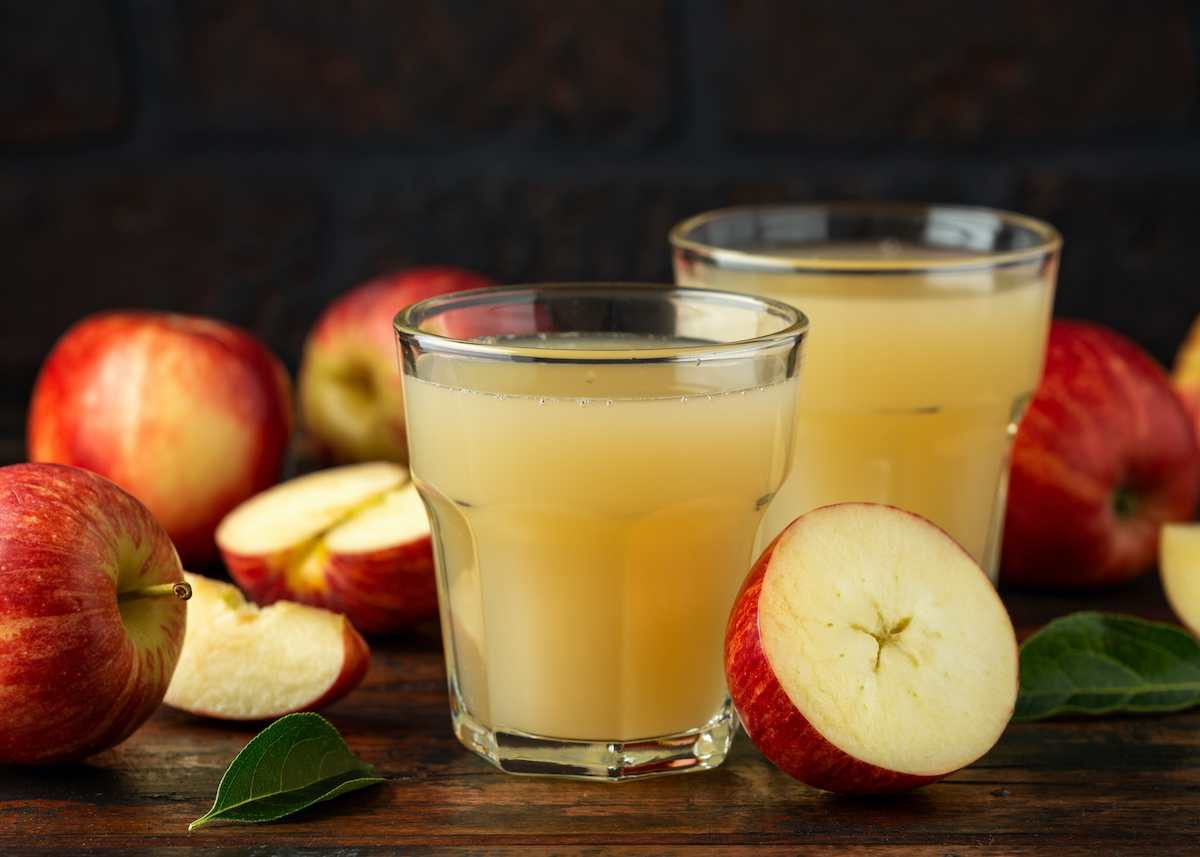 Apple juice in glass on rustic wooden table